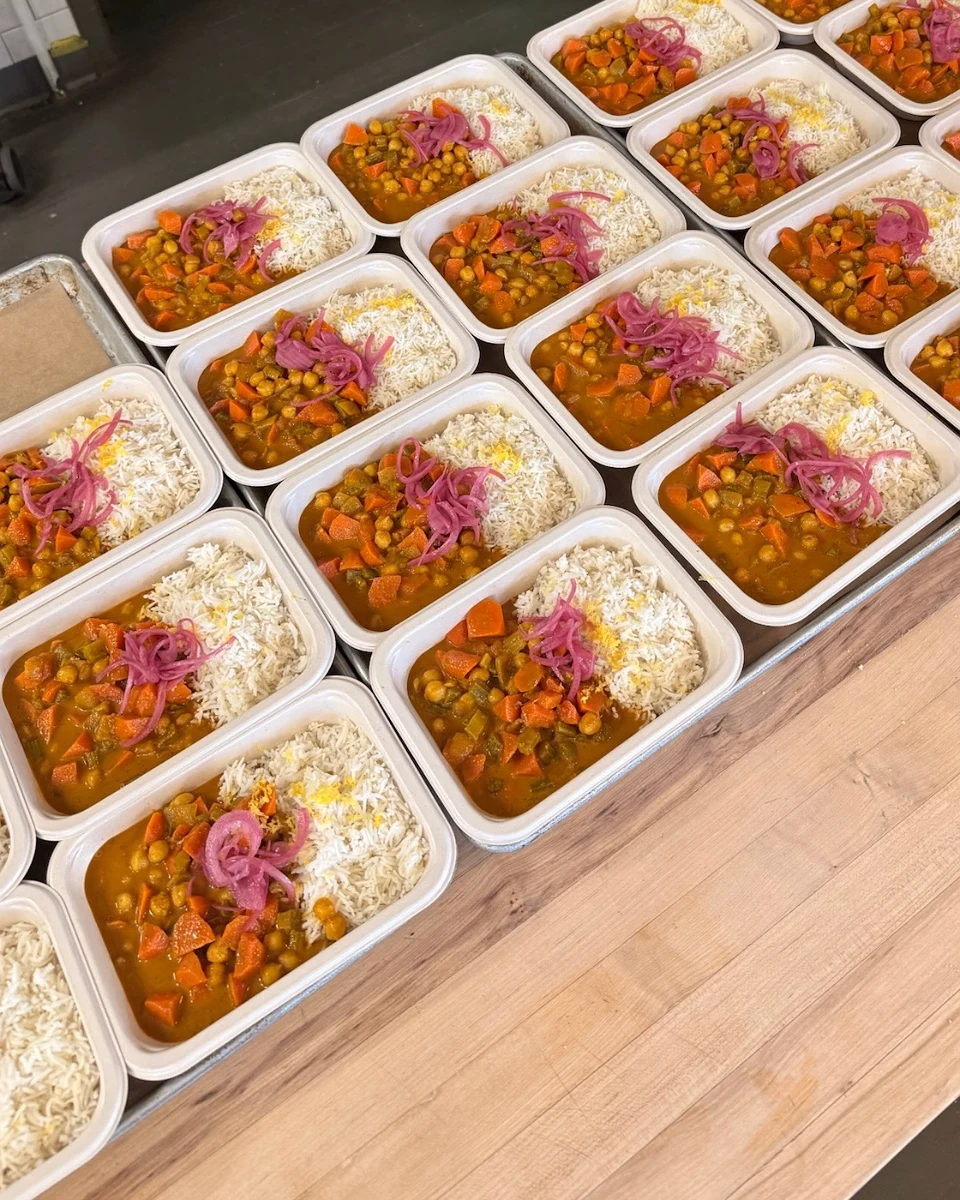 Chickpea curry with rice and pickled onion, packed and lined up in the Navo kitchen